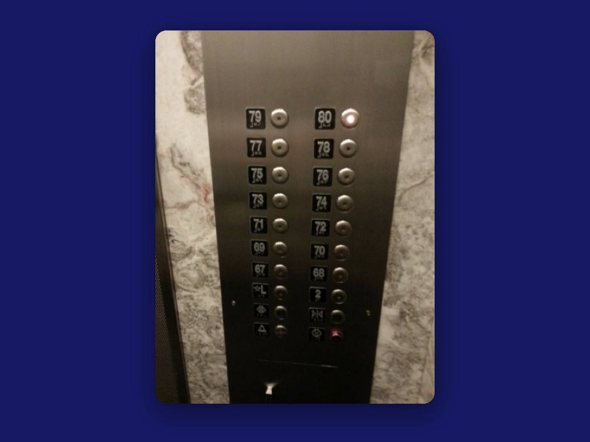 A tall elevator button panel with two columns of floor buttons for the upper floors, each with a small braille label